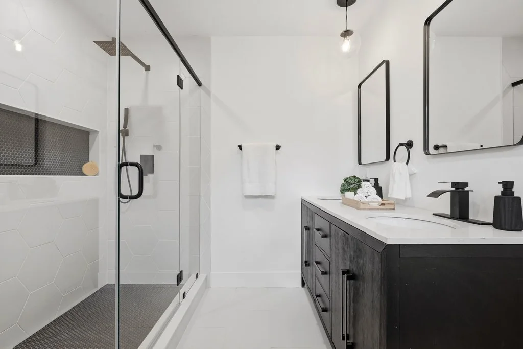 Finished primary bathroom with walk-in shower and double vanity